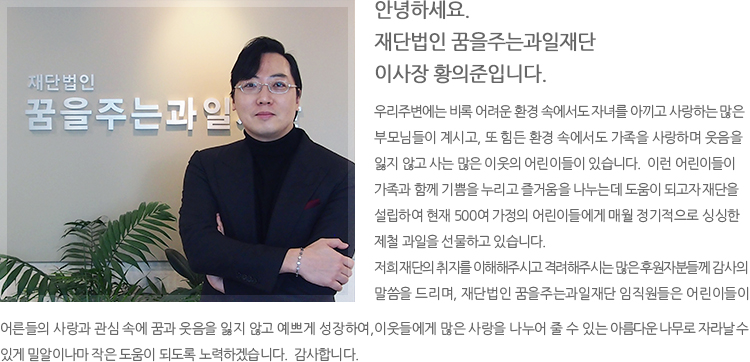 한 손에는 초록색 사과하나를 다른 손에는 화분을 들고 웃고 있는 아이사진